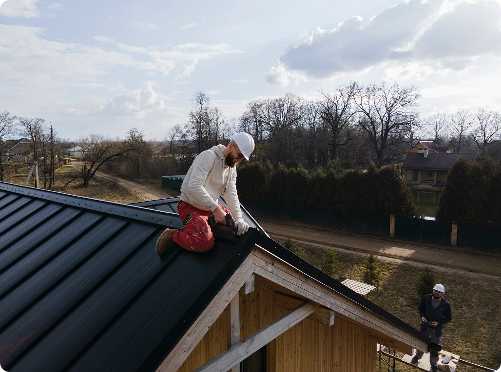Artisan couvreur zingueur travaillant sur le toit d'une maison en Isère